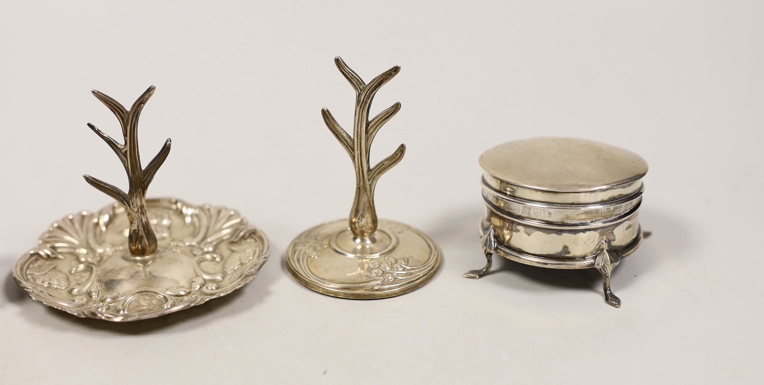 Two early 20th century silver ring stands, tallest 7cm, a small silver mounted trinket box and a 19th century inlaid wooden snuff box